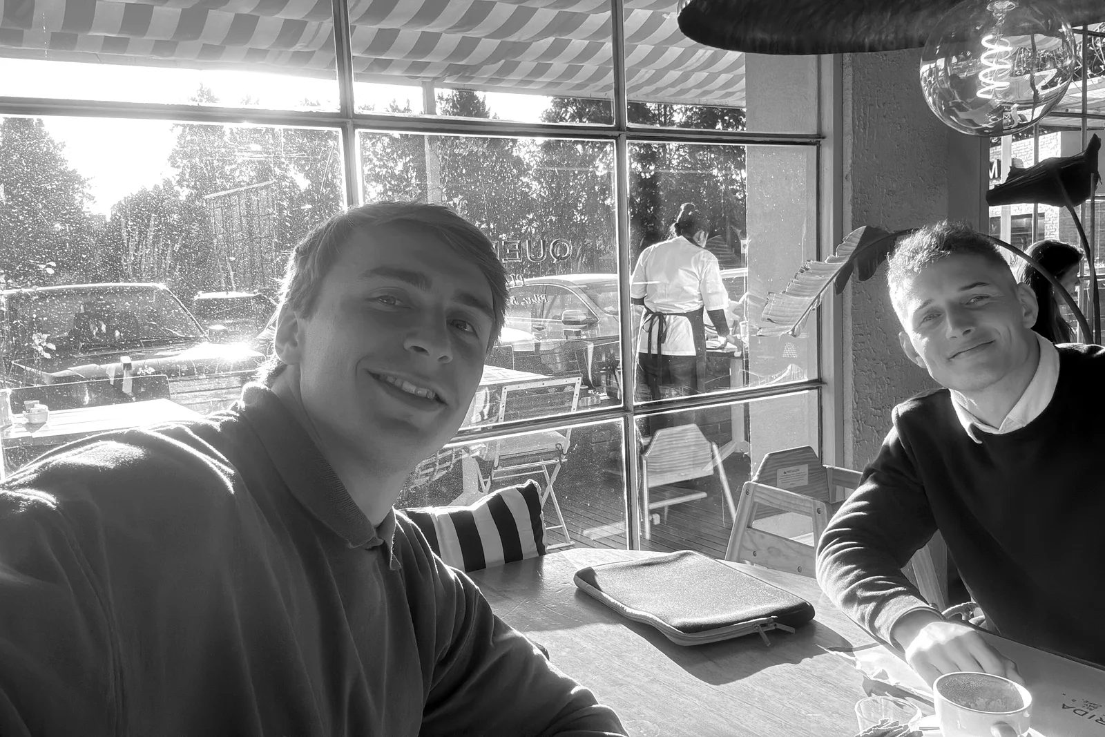 Joaquín Moresco y Tadeo Ustariz, sentados a una mesa junto a un ventanal.